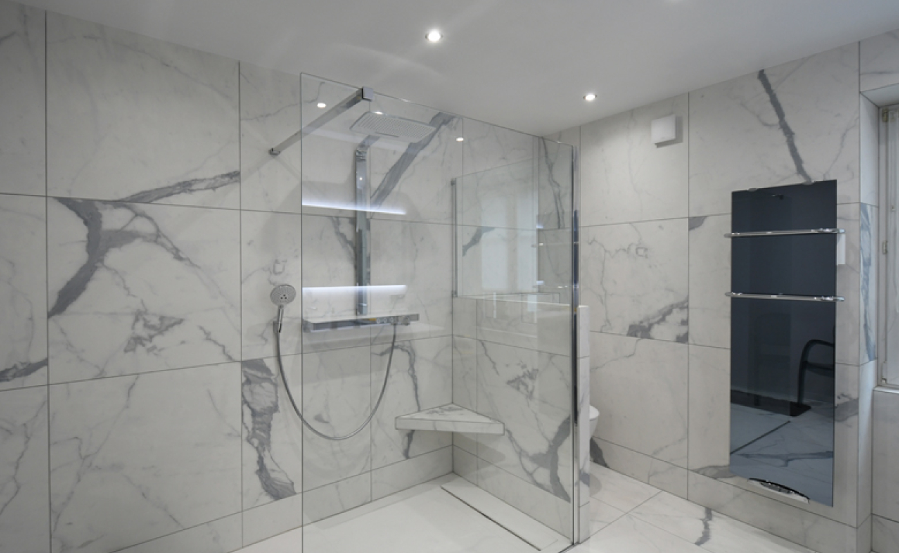 Du travail de pro. L’entreprise Schuler a redonné vie à cette salle de bains entièrement revêtue d’un carrelage imitation marbre.